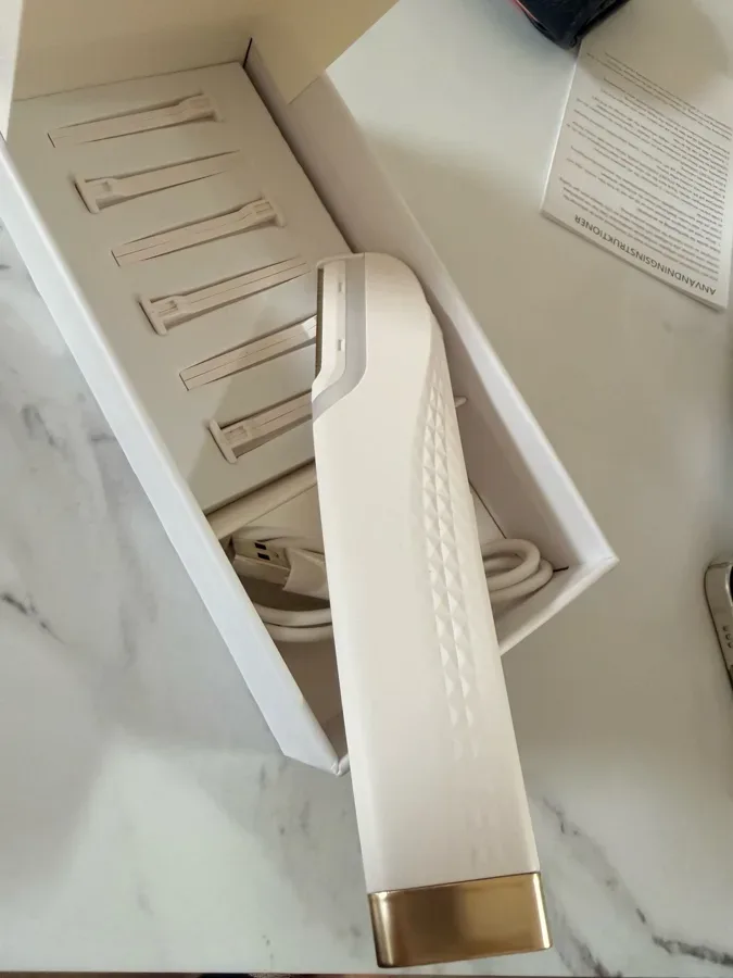Peachly electric dermaplane tool, white body with gold accents