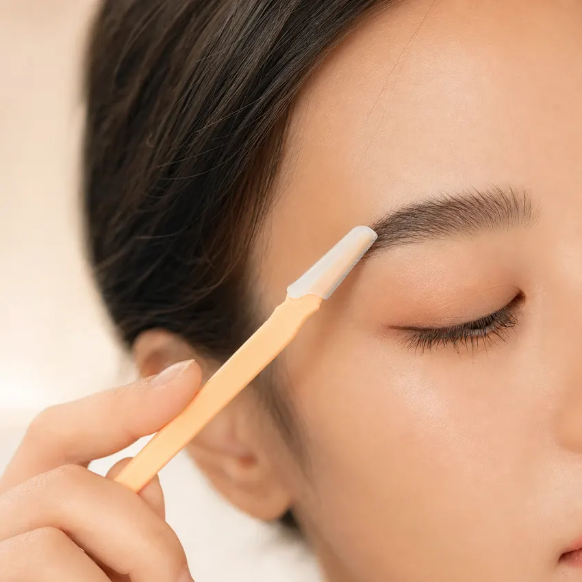 Peachly eyebrow razor being used to shape and define the brow on clean, dry skin
